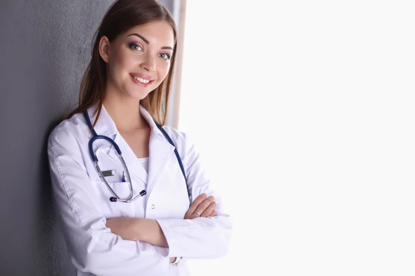 Médecin femme avec stéthoscope debout près du mur gris — Photo