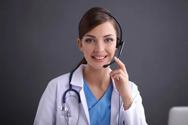 Doctor wearing headset sitting behind a desk with laptop — Stock Photo, Image