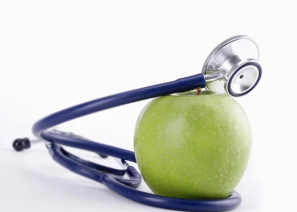 Stetoskop ve yeşil elma beyaz arkaplanda izole edilmiş. , — Stok fotoğraf