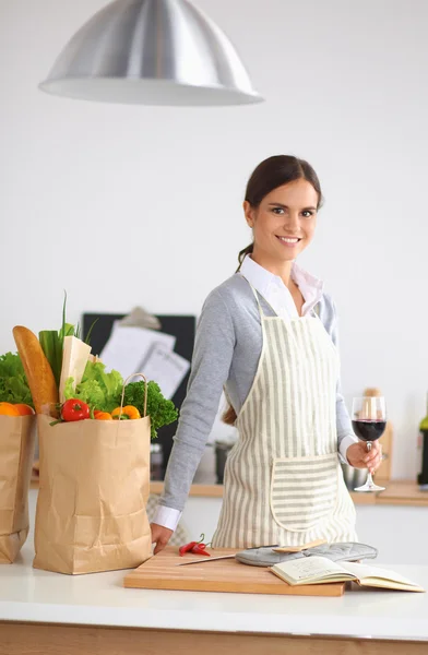 Vrouw met boodschappentassen in de keuken thuis, bij het bureau — Stockfoto