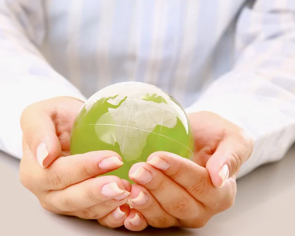 Manos sosteniendo una tierra verde, aisladas sobre fondo blanco — Foto de Stock