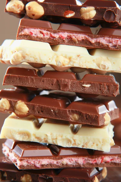 Stack of chocolate pieces on a wood background — Stock Photo, Image