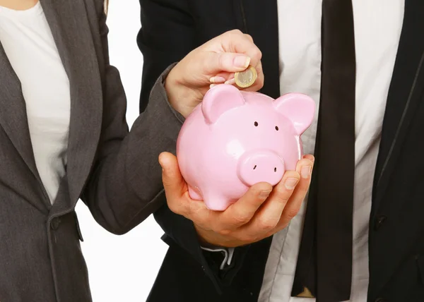 A businesswoman and man putting a coin into a piggy bank isolated on white background. — Stock Photo, Image
