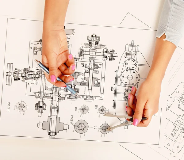 Female architect working with blueprints at office desk — Stock Photo, Image