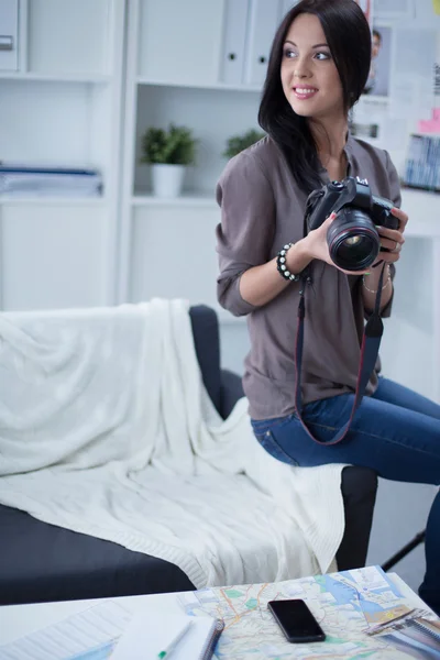 Mulher é uma fotógrafa profissional com câmera no escritório — Fotografia de Stock