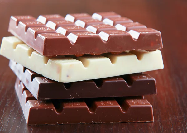 Stack of chocolate pieces on a wood desk — Stock Photo, Image