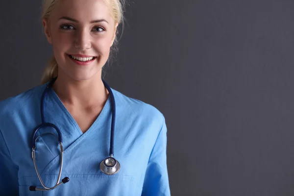 Junge Ärztin mit Stethoskop isoliert auf grauem Hintergrund — Stockfoto