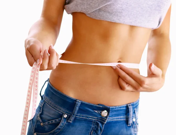 A young woman measuring her waist isolated on white background. — Stock Photo, Image