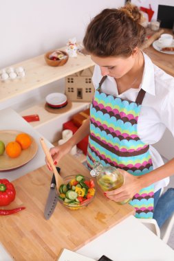 Gülümseyen genç kadın taze salata hazırlıyor.