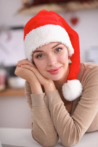 Mujer joven sonriente en la cocina, aislada en el fondo de Navidad — Foto de Stock