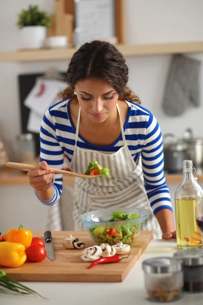 Genç kadın modern mutfakta taze salata yiyor. — Stok fotoğraf