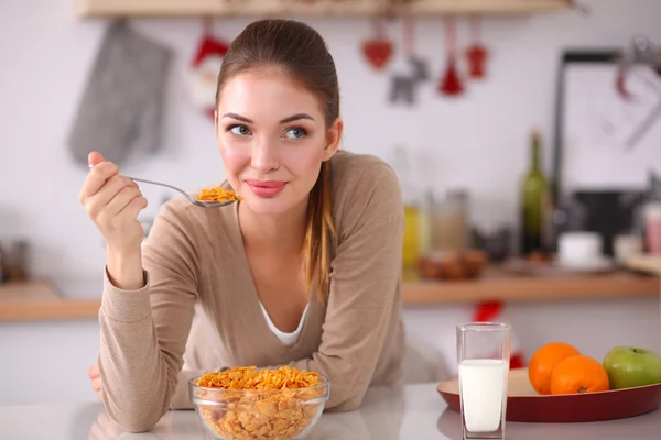 Sorridente donna attraente che fa colazione in cucina interna — Foto Stock