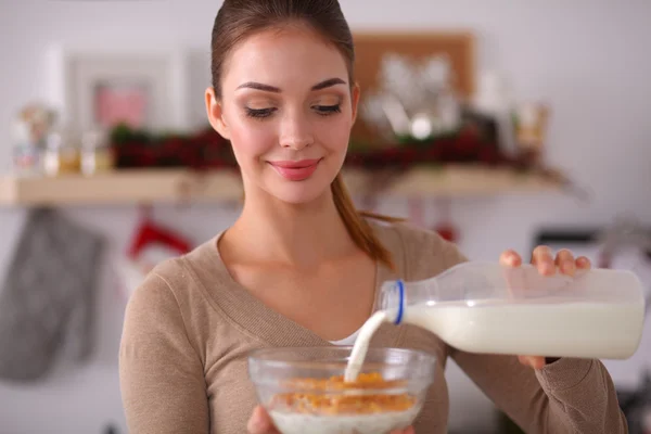 Mujer atractiva sonriente desayunando en el interior de la cocina — Foto de Stock