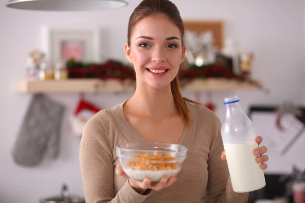 Leende attraktiv kvinna som äter frukost i köket interiör — Stockfoto