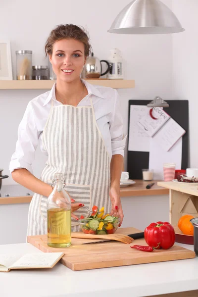 Junge Frau isst frischen Salat in moderner Küche — Stockfoto