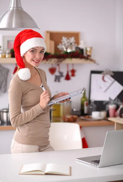 Sorridente giovane donna in cucina, isolata su sfondo natalizio — Foto Stock