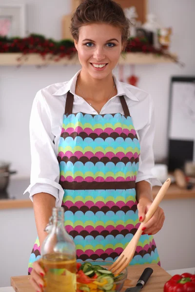 Mujer joven comiendo ensalada fresca en la cocina moderna — Foto de Stock