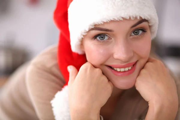 Χαμογελαστή νεαρή γυναίκα στην κουζίνα, απομονωμένη στο φόντο των Χριστουγέννων — Φωτογραφία Αρχείου