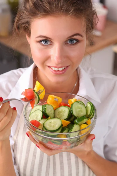 Молода жінка їсть свіжий салат на сучасній кухні — стокове фото