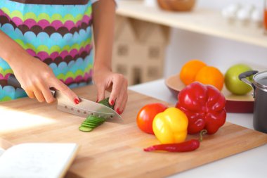 Kadın mutfakta salata hazırlıyor.