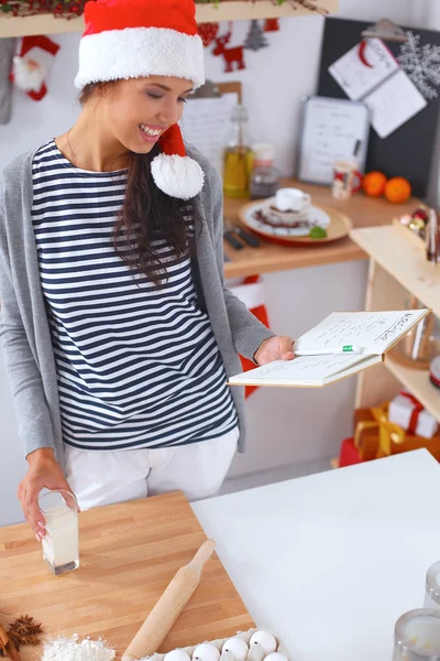 Felice giovane donna sorridente felice divertirsi con preparazioni di Natale indossando il cappello di Babbo Natale — Foto Stock