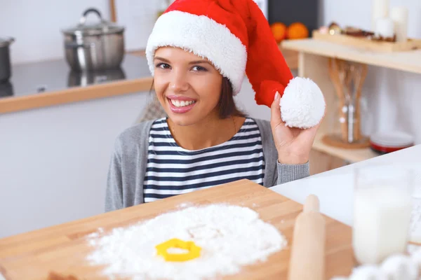 Heureuse jeune femme souriante heureuse de s'amuser avec les préparatifs de Noël portant le chapeau de Père Noël — Photo