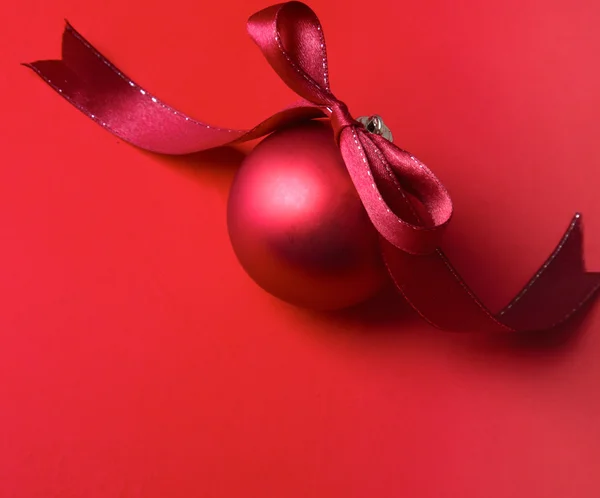 Czerwoną piłkę Bożego Narodzenia, na białym tle na czerwonym tle. — Zdjęcie stockowe