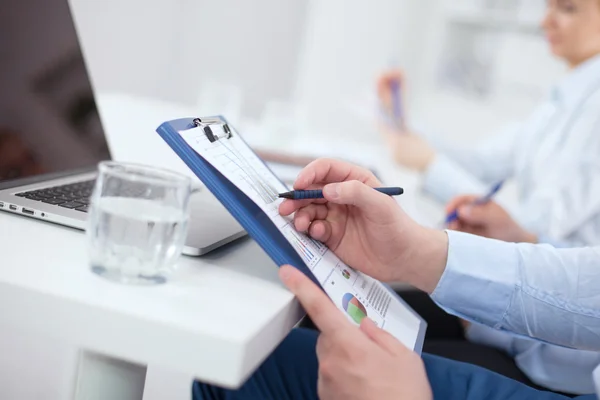 Close-up of businessman explaining a financial plan to colleagues at meeting — Stock Photo, Image