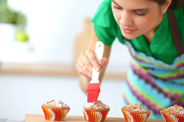 Vrouw bakt taarten in de keuken. — Stockfoto