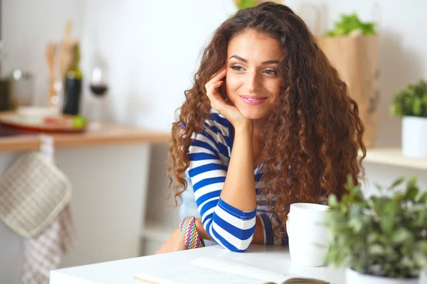 Smiling young woman in the kitchen, isolated on  background — Stock Photo, Image