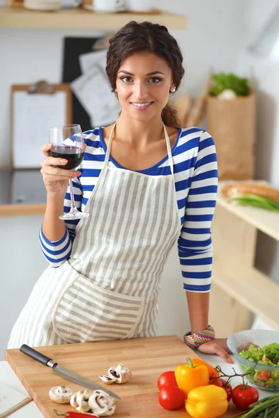 Jonge vrouw snijden groenten in de keuken — Stockfoto