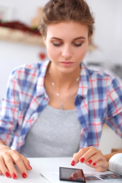 Mujer sonriente compras en línea utilizando la computadora y la tarjeta de crédito en la cocina — Foto de Stock