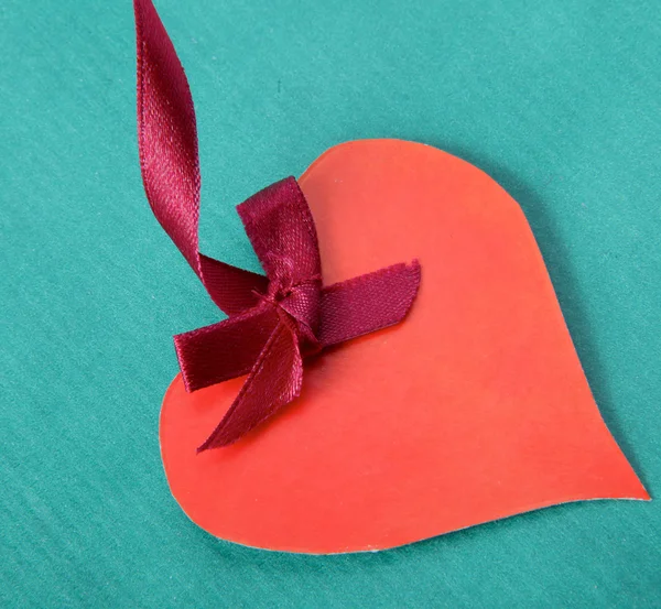 Corazón con cinta roja aislada sobre fondo verde —  Fotos de Stock