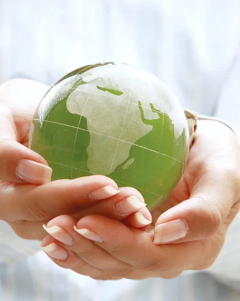 Manos sosteniendo una tierra verde — Foto de Stock