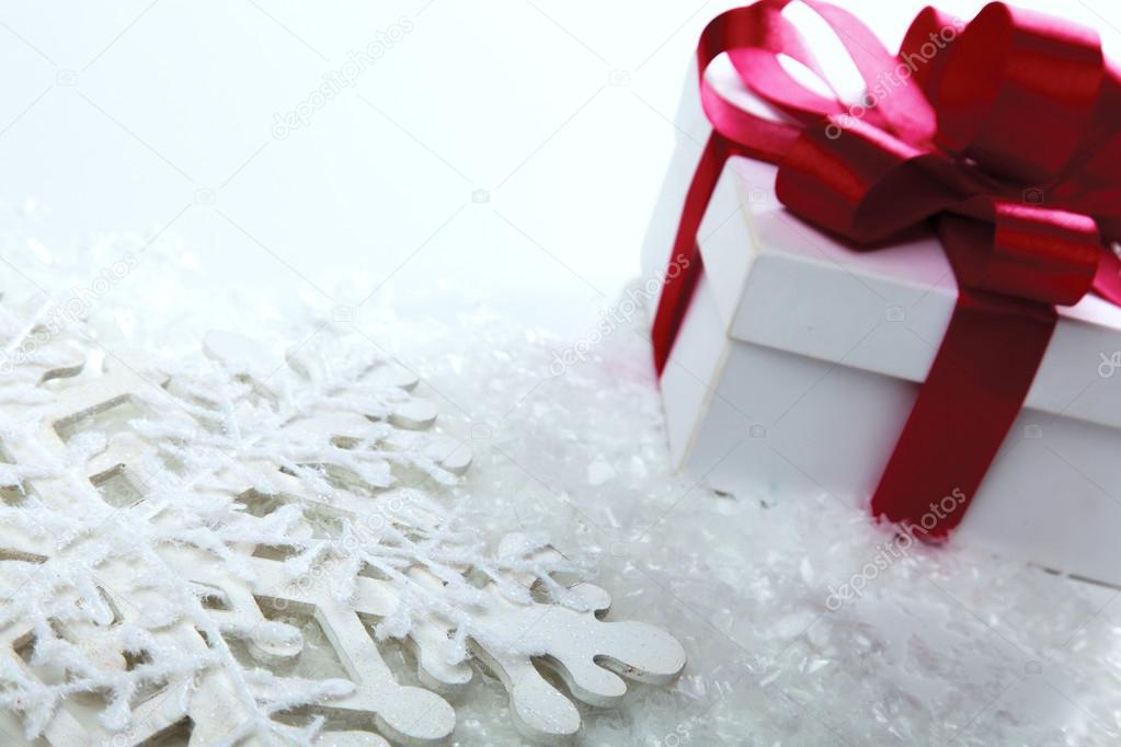 Decorative white gift box with a red bow a background bokeh.