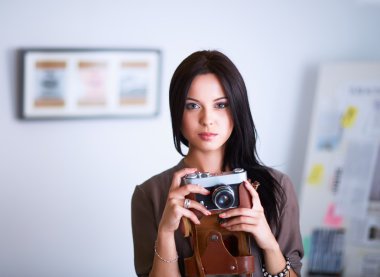 Genç bir kadın film izliyor, pencerenin yanında duruyor.