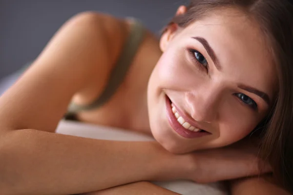 Gros plan d'une jeune femme souriante allongée sur le canapé — Photo