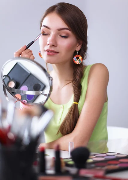 Ung vacker kvinna gör make-up nära spegeln — Stockfoto