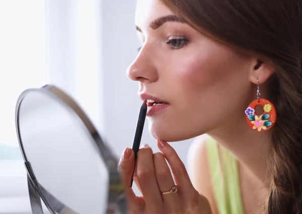 Young beautiful woman making make-up near mirror — Stock Photo, Image