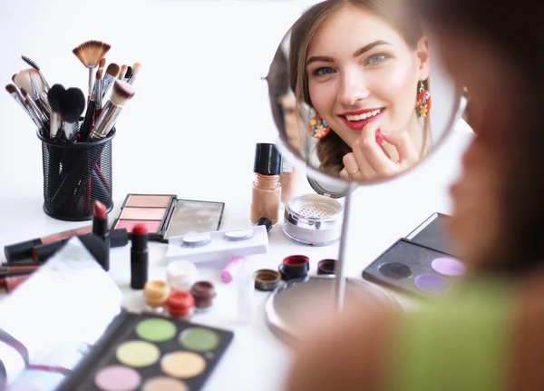 Ung vacker kvinna gör make-up nära spegeln — Stockfoto