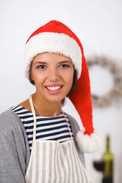 幸せな若い女性笑顔幸せを持って楽しみますクリスマスの準備を身に着けているサンタの帽子 — ストック写真