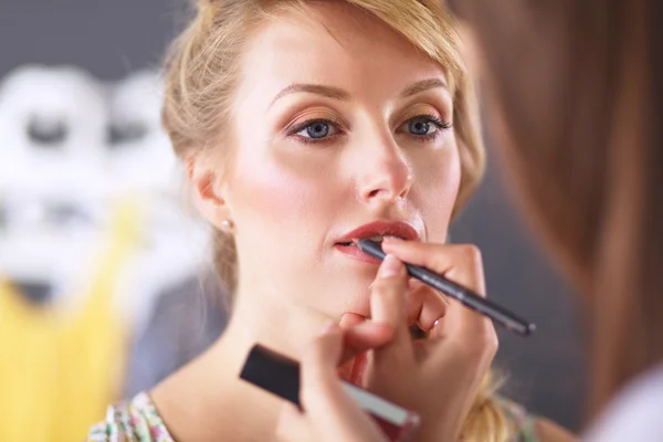 Konstnär gör professionell make up av kvinna — Stockfoto