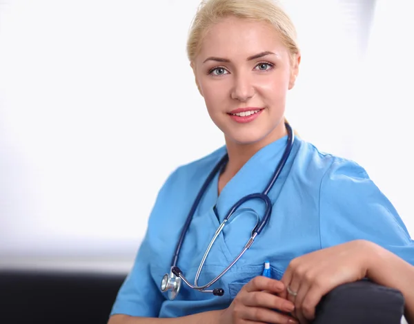 Portrait of a happy young doctor sitting on the sofa — Stock Photo, Image