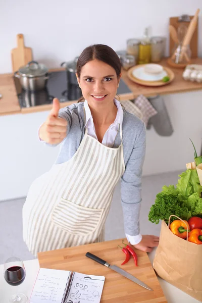 Mujer con bolsas de compras en la cocina en casa, de pie cerca del escritorio — Foto de Stock