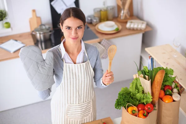 制作健康食品站在厨房里微笑的女人 — 图库照片