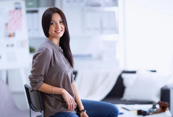 Young woman watching footage on film, standing near window — Stock Photo, Image