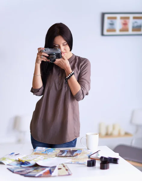 Jonge vrouw kijken naar beelden op film, staan in de buurt van raam — Stockfoto