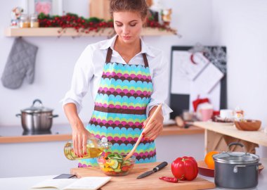 Gülümseyen genç kadın taze salata hazırlıyor.