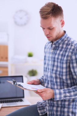 Ofiste oturan kırmızı klasör ile gülümseyen iş adamı