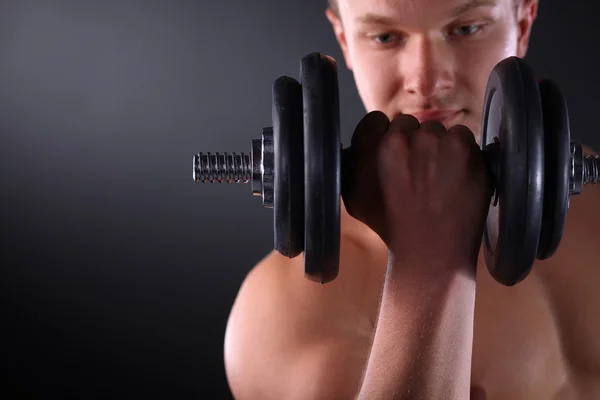 Schöner muskulöser Mann, der mit Hanteln trainiert — Stockfoto